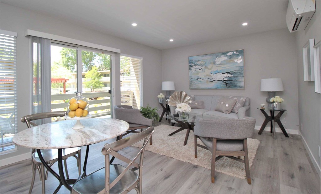 a living room and dining room with a table and chairs