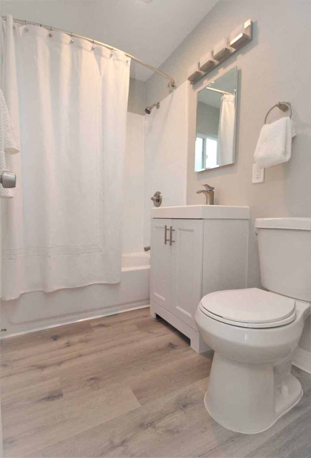 a bathroom with a white toilet and a white shower curtain