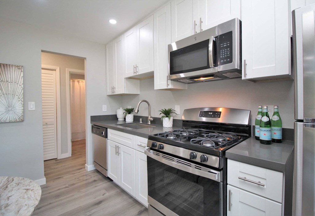 a kitchen with stainless steel appliances and white cabinets