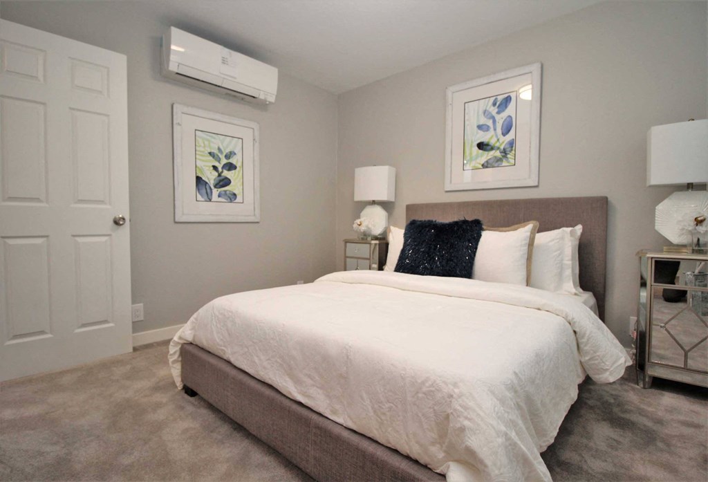 a bedroom with a large bed and two paintings on the wall