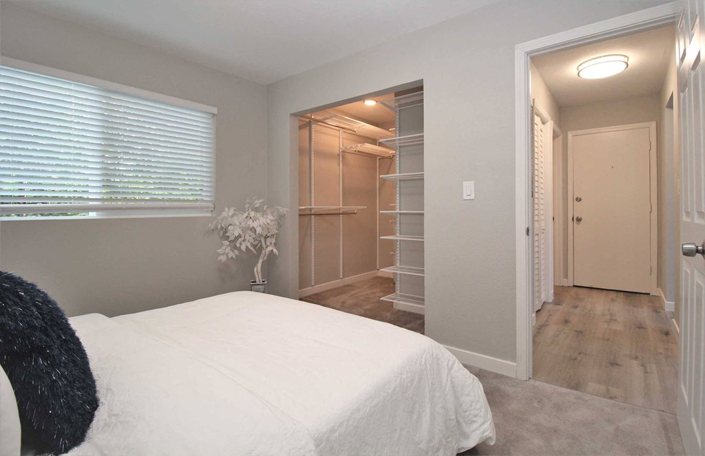 a bedroom with a large white bed and a closet