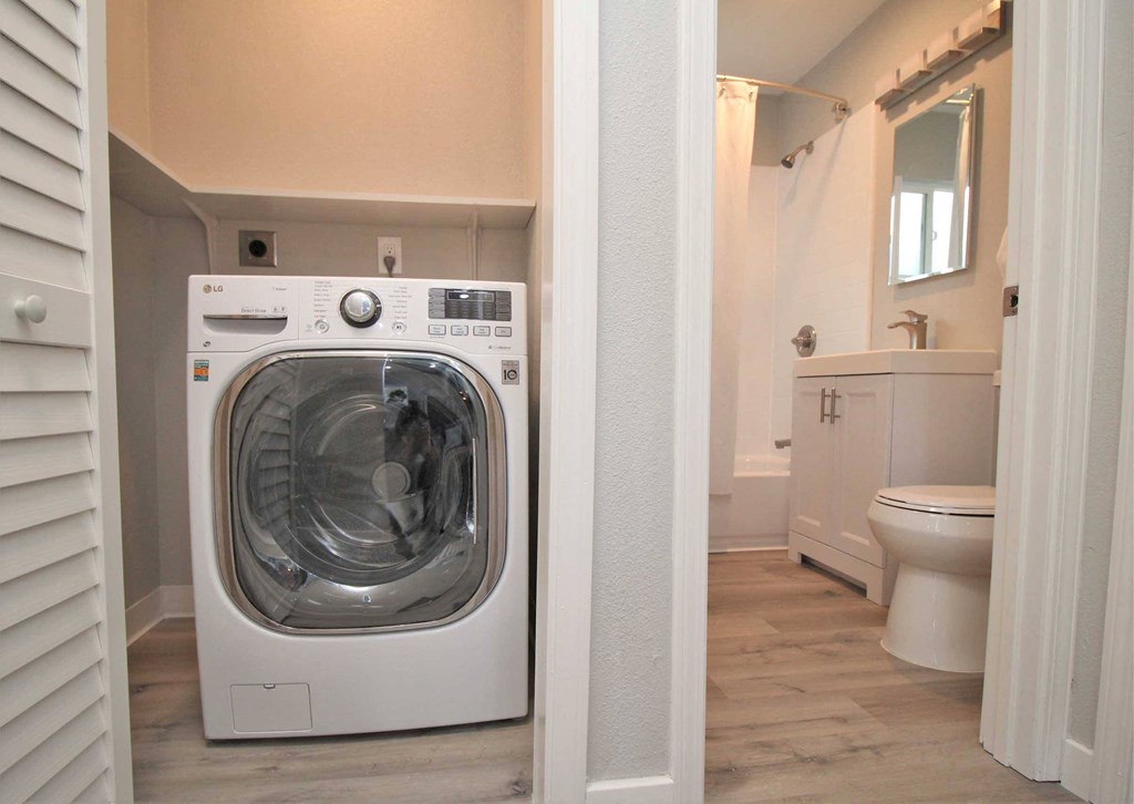 a washer and dryer in a bathroom next to a toilet
