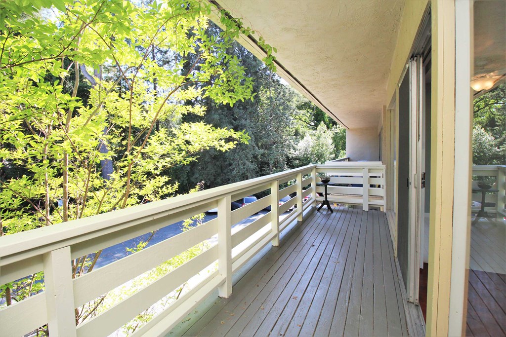 a balcony with a view of trees and a deck