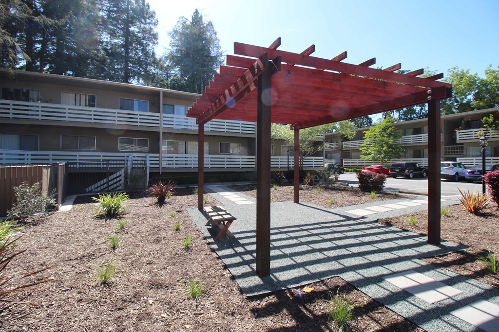 a covered area with a bench in front of a building