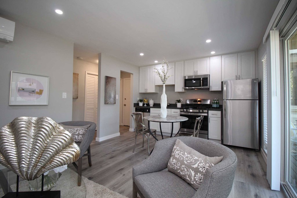 a renovated living room and kitchen with a table and chairs