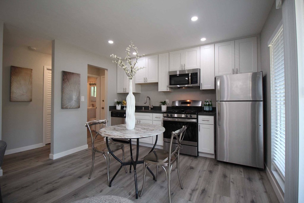 a kitchen with stainless steel appliances and a table with chairs
