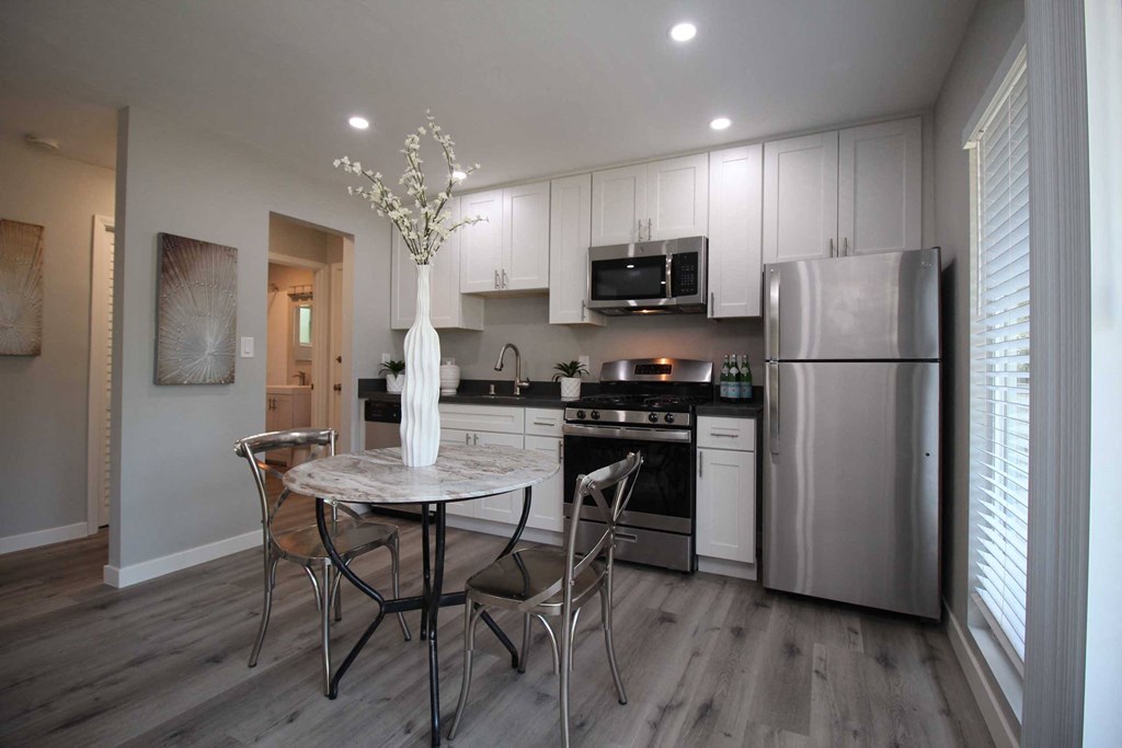 a kitchen with stainless steel appliances and a table with chairs
