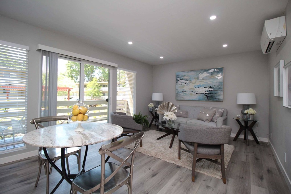 a living room and dining room with a table and chairs