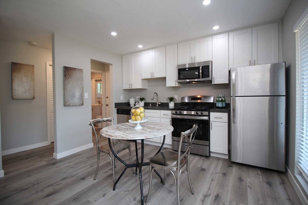 a kitchen with stainless steel appliances and a table with chairs