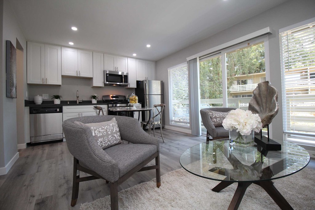 a view of a living room with a glass table and chairs