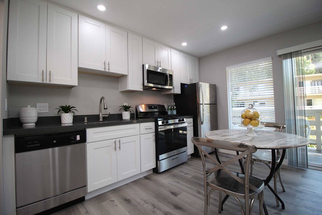 a kitchen with white cabinets and a table and chairs