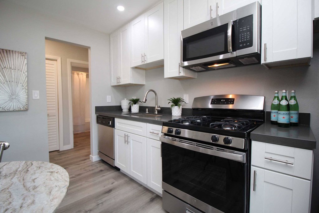 a kitchen with stainless steel appliances and white cabinets