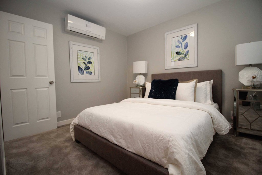 a bedroom with a large bed and a air conditioner