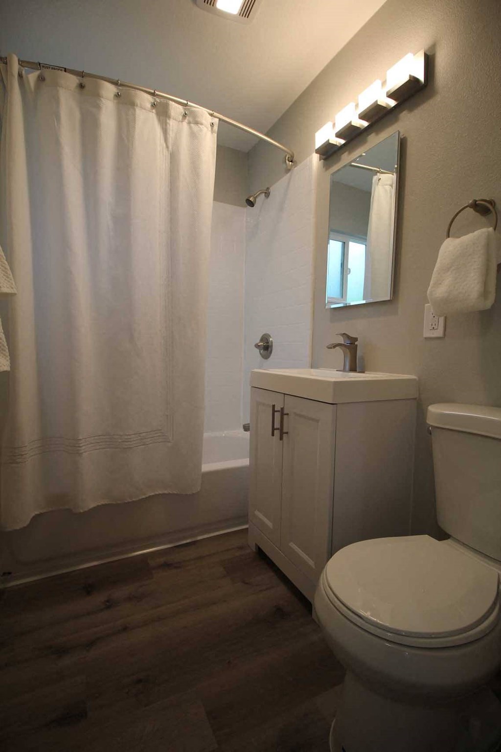 a bathroom with a toilet and a sink and a shower curtain