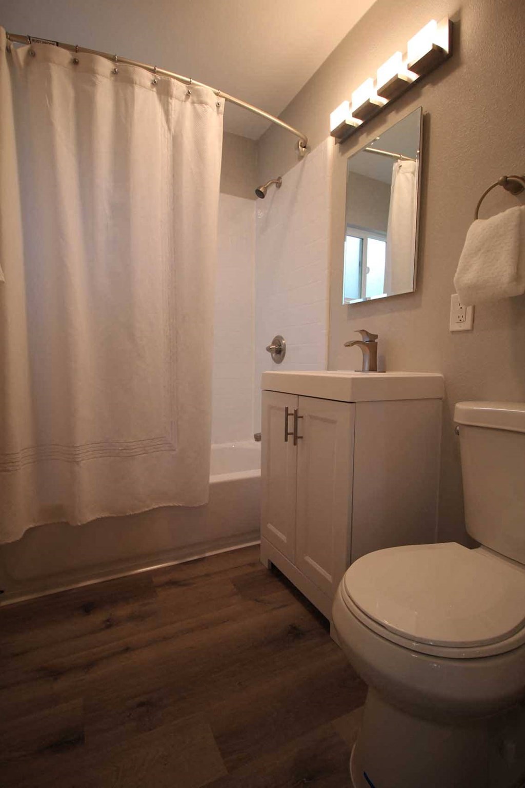 a bathroom with a white toilet and a white shower curtain