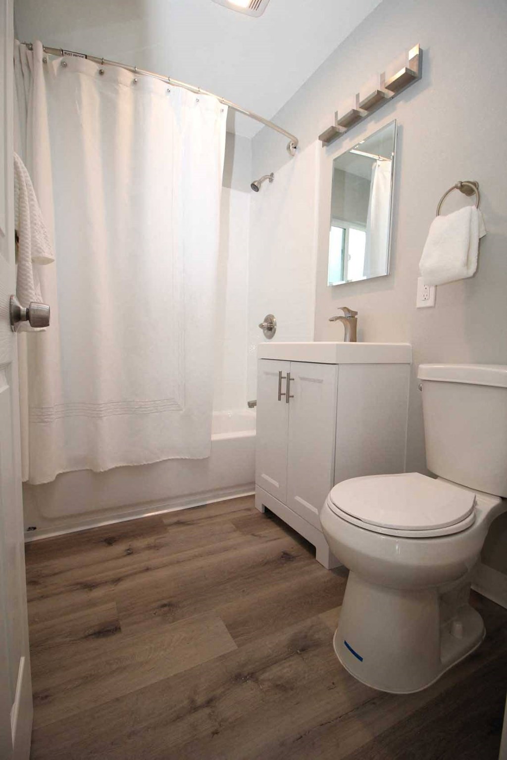 a bathroom with a white toilet and a white shower curtain