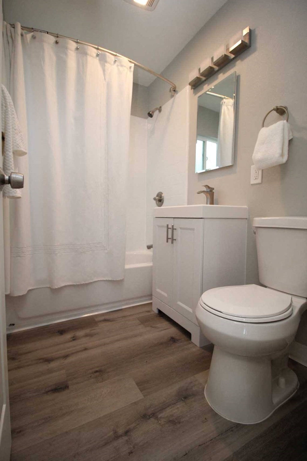 a bathroom with a white toilet and a white shower curtain