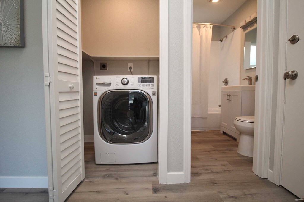 a washer and dryer in a bathroom next to a toilet