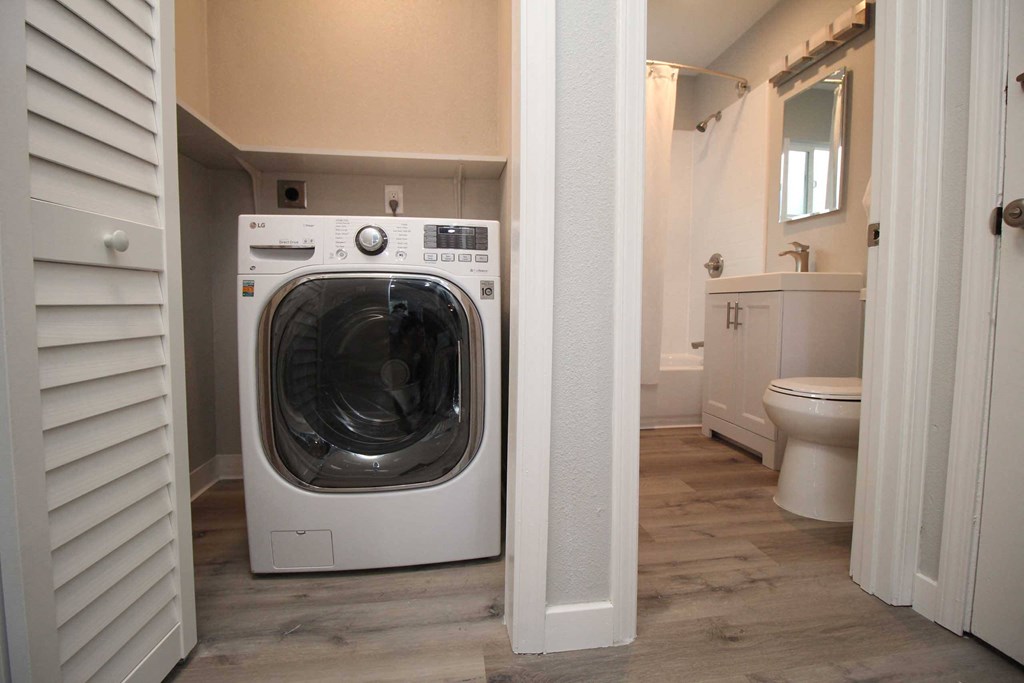 a washer and dryer in a bathroom with a toilet