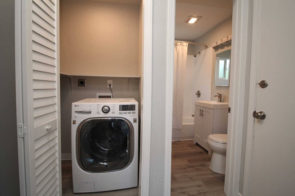 a washer and dryer in a bathroom next to a toilet