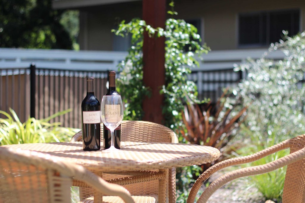 two bottles of wine sitting on a patio table