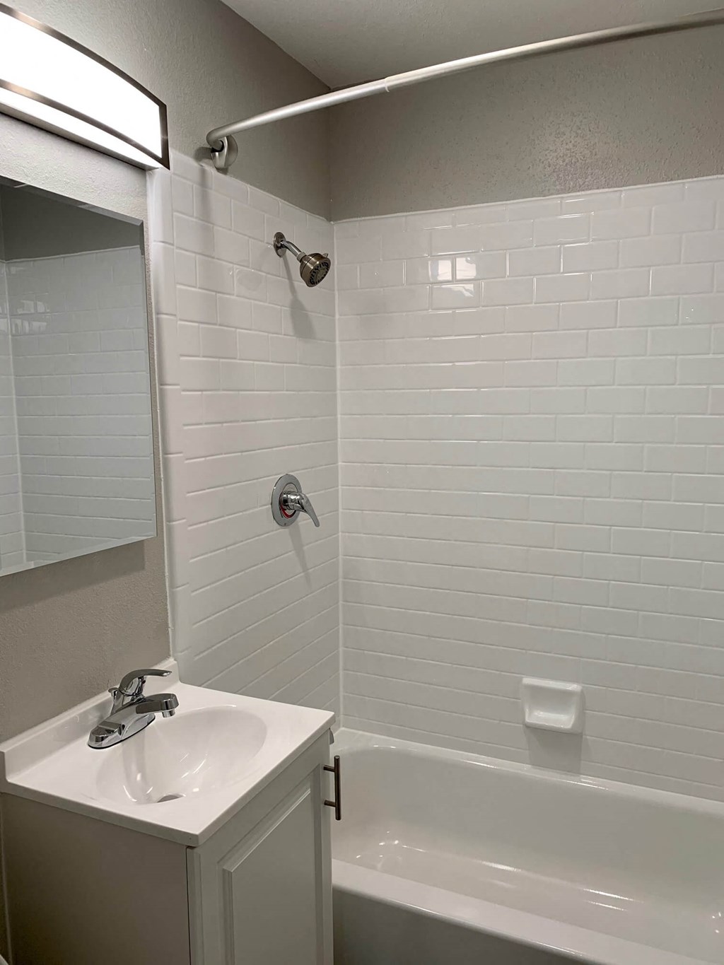 a bathroom with a sink and a tub and a mirror