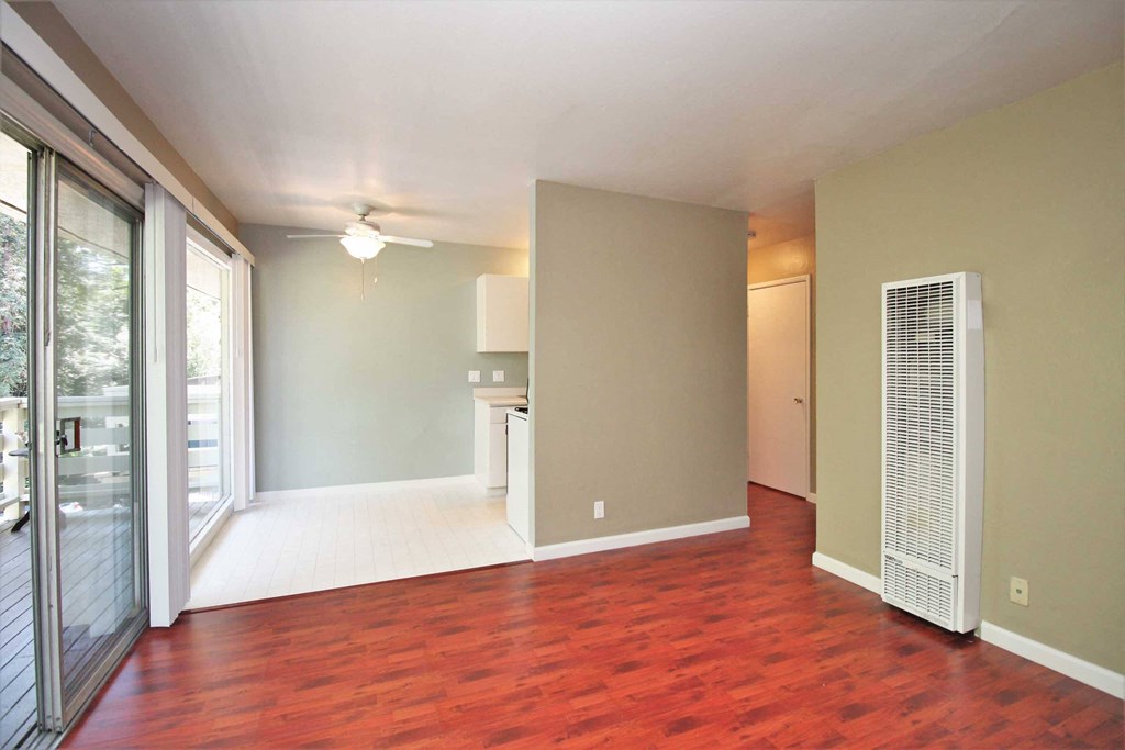 an empty living room with wood flooring and sliding glass doors