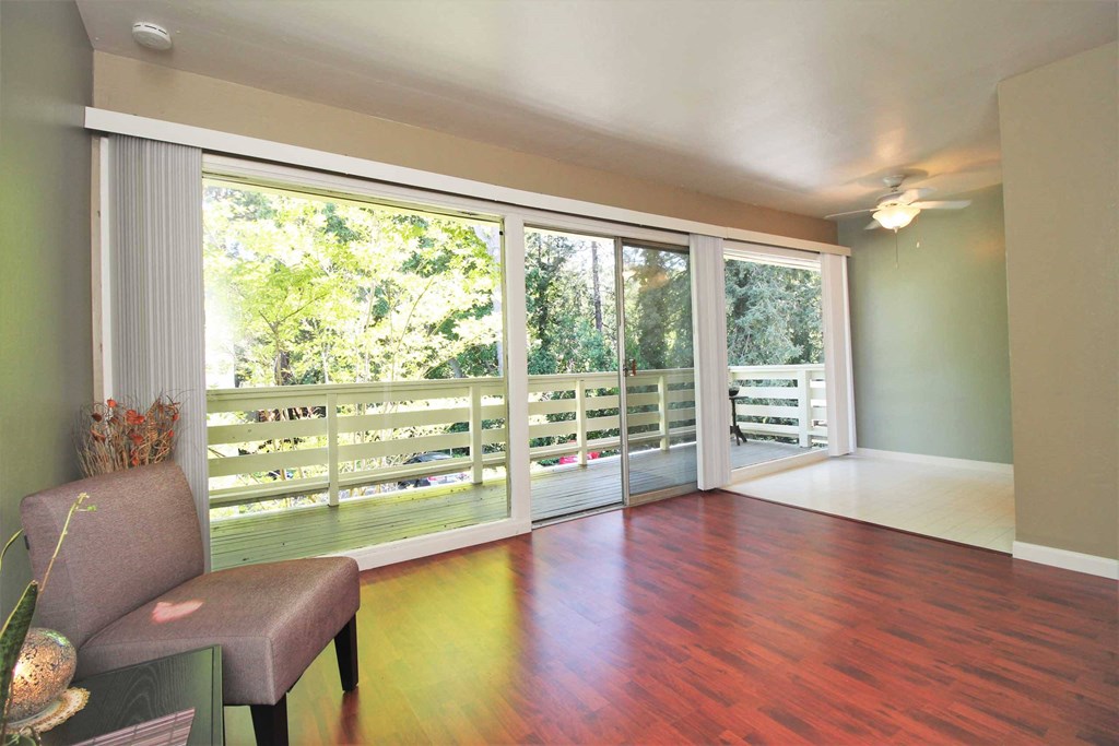 a living room with hard wood floors and sliding glass doors