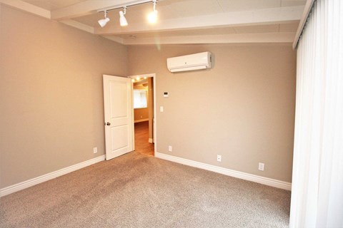 an empty living room with a heater on the wall
