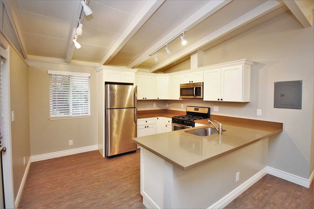 a kitchen with an island and a stainless steel refrigerator