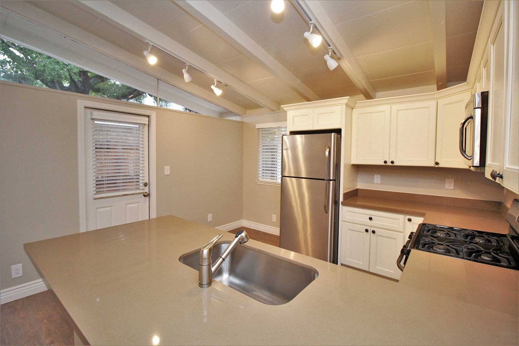 a kitchen with white cabinets and a stainless steel refrigerator
