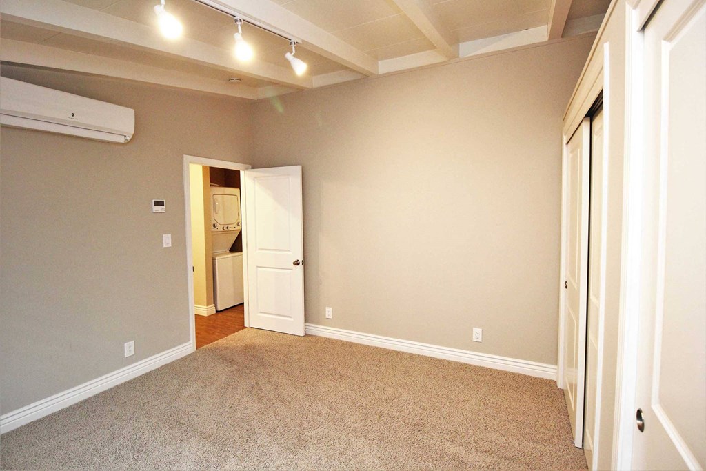 a living room with white walls and a door to a hallway