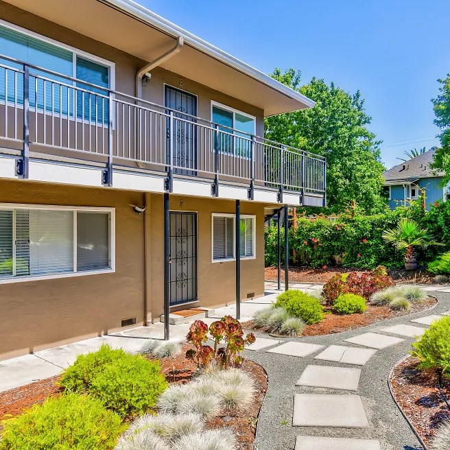a house with a balcony and a walkway in front of it