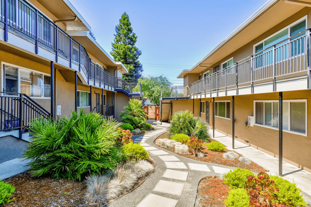 the courtyard of a building with a pathway and plants