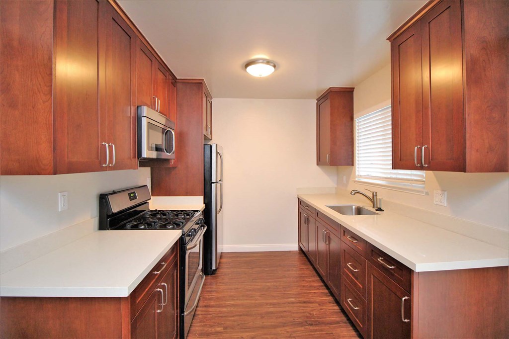 a kitchen with wooden cabinets and a stove and refrigerator