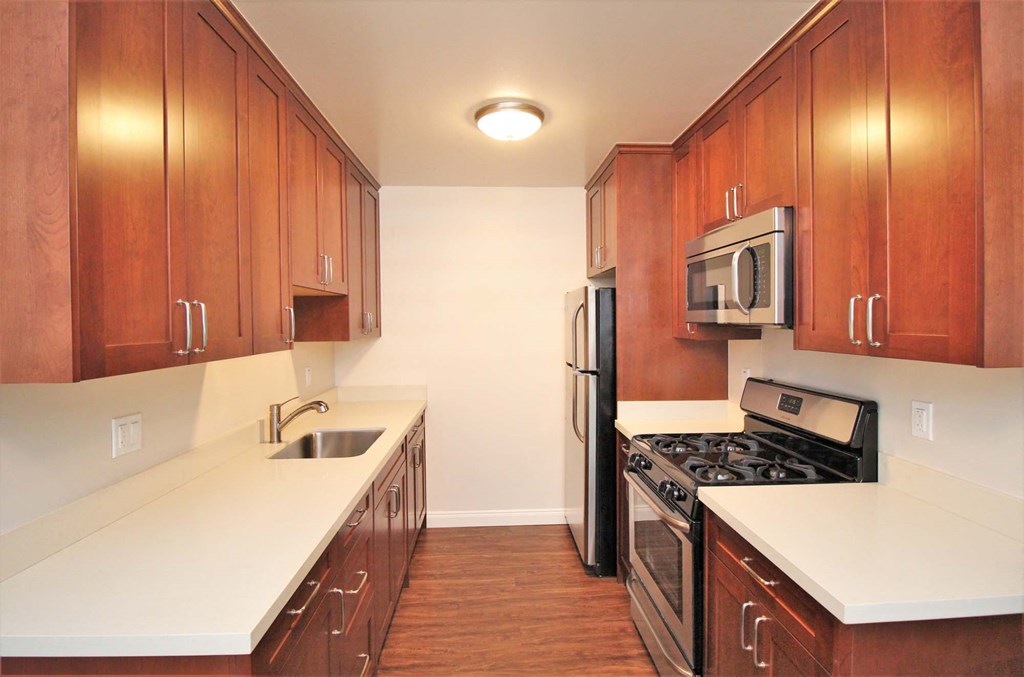 a kitchen with wooden cabinets and stainless steel appliances