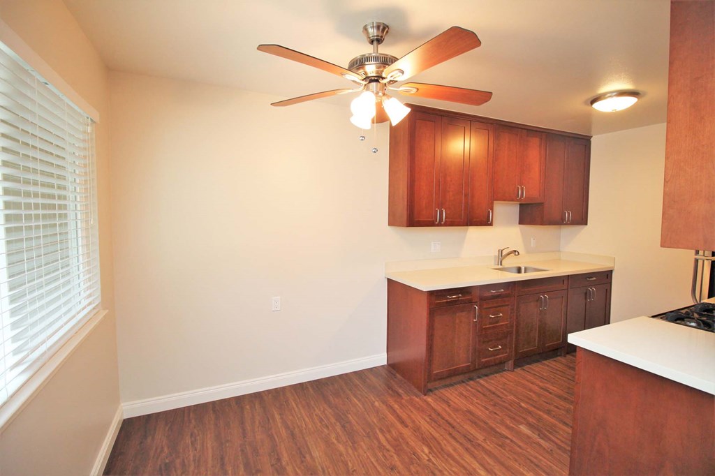 a kitchen with wooden cabinets and a ceiling fan