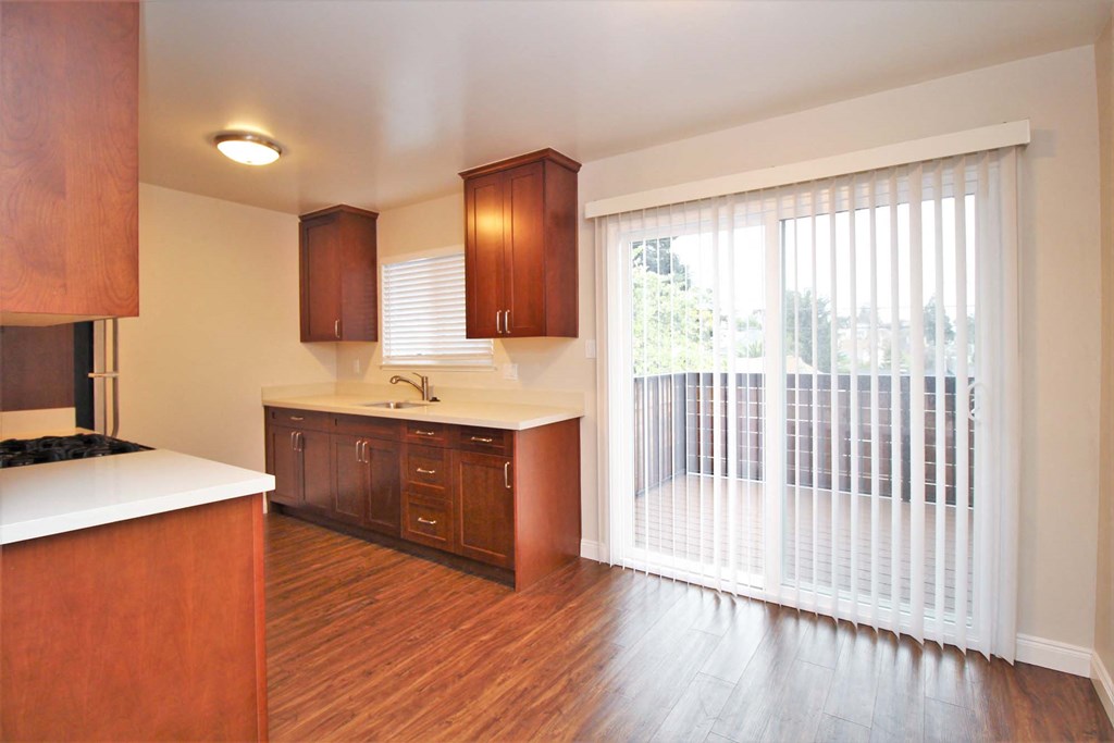 a kitchen with a sliding glass door leading to a balcony
