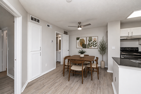 A dining room with a table and chairs.