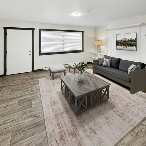 A living room with a grey couch, a coffee table, and a painting on the wall.