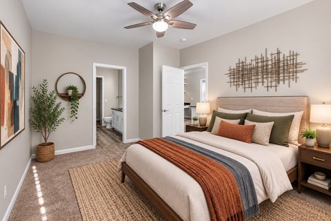 A bedroom with a large bed and a ceiling fan.
