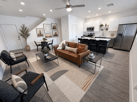 A modern living room with a brown leather couch and a glass coffee table.