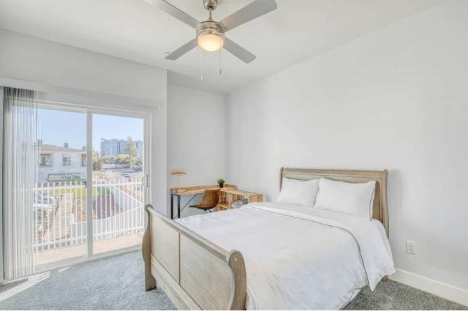 A bedroom with a large bed and a ceiling fan.