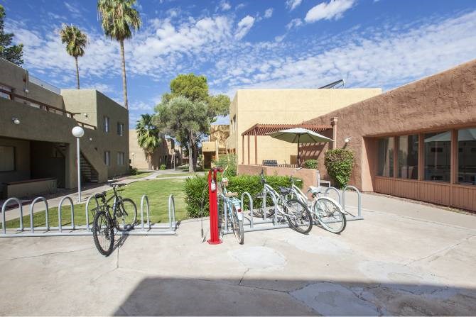 A red fire hydrant is in front of a bike rack.