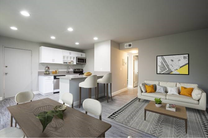 A modern living room with a dining area and kitchen in the background.