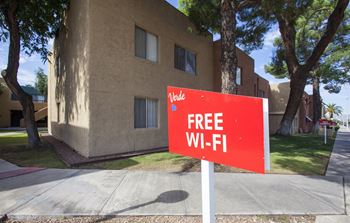 A red sign offering free Wi-Fi in front of a building.