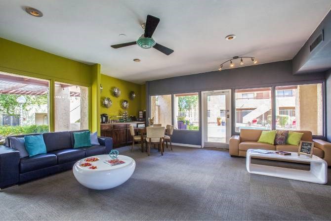 A living room with a blue couch and a white coffee table.