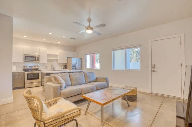A living room with a couch, chair, and a fan.