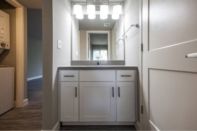 A bathroom with a vanity and a mirror.