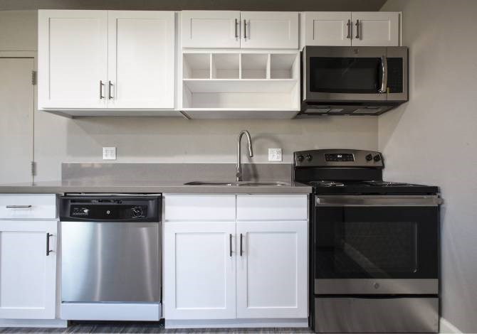 A kitchen with white cabinets and stainless steel appliances.